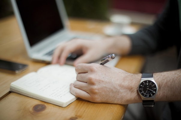 a person writing on a piece of paper