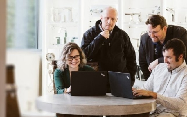 a group of people looking at a laptop